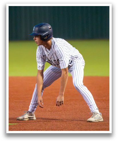 A baseball player in a blue helmet and striped uniform is crouching on the field. Contenido generado con IA
