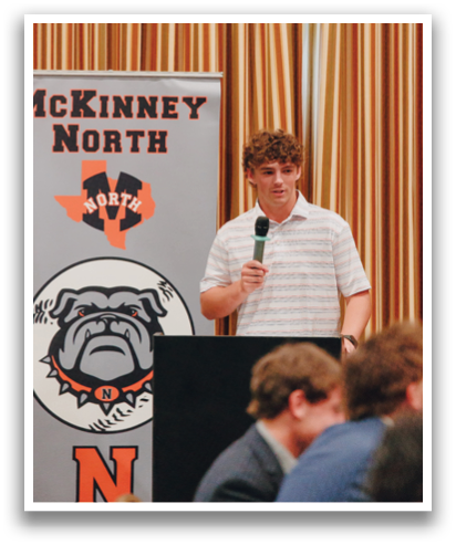 A man in a striped shirt stands at a podium, speaking into a microphone. Contenido generado con IA