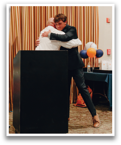 Two men hugging in front of a podium. Contenido generado con IA