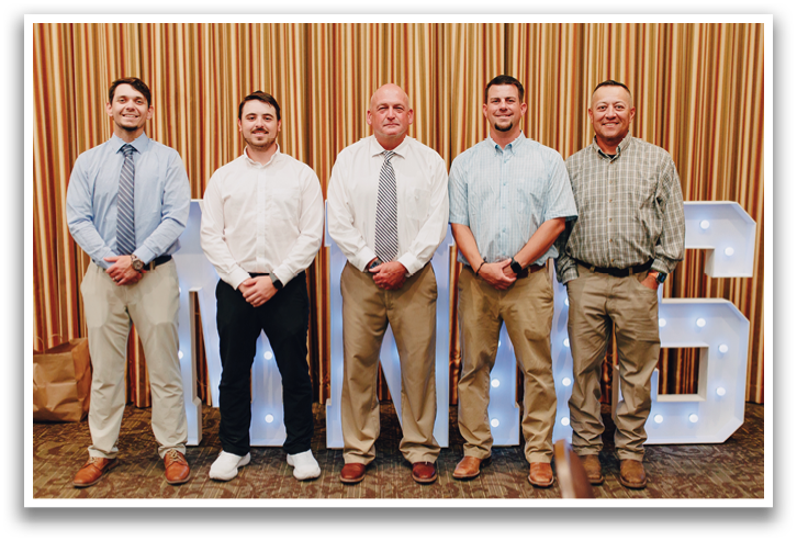 Four men wearing ties and shirts pose for a picture. Contenido generado con IA