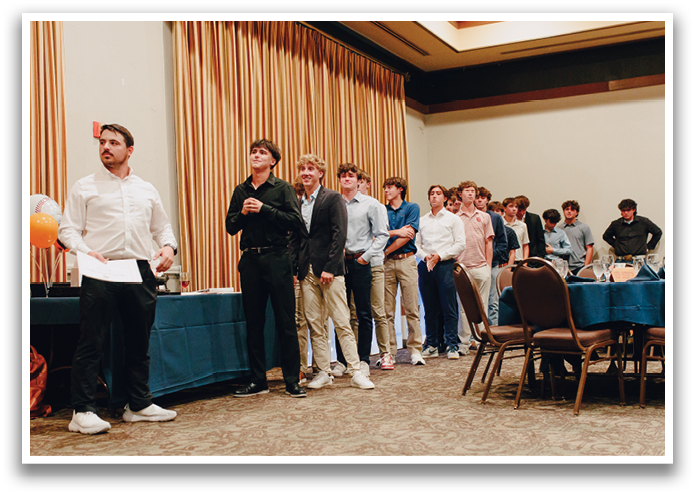 A group of young men stand in a line in a room, some wearing ties. Contenido generado con IA