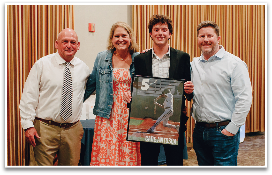 Three people pose for a photo, one of them holding a framed item. Contenido generado con IA