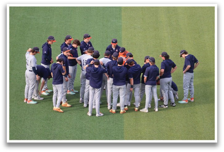 A group of baseball players in uniforms are standing on a field, huddled together. Contenido generado con IA