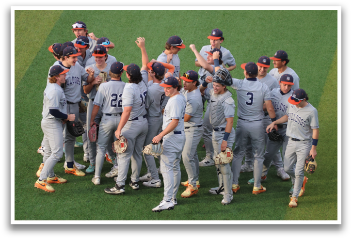 A group of baseball players huddled together on the field, wearing grey uniforms and holding baseball gloves. Contenido generado con IA