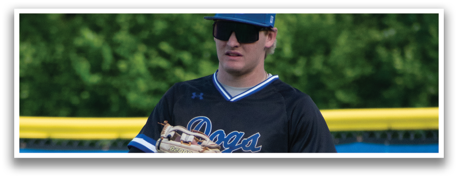 A baseball player wearing a black shirt and blue hat. Description generated by AI