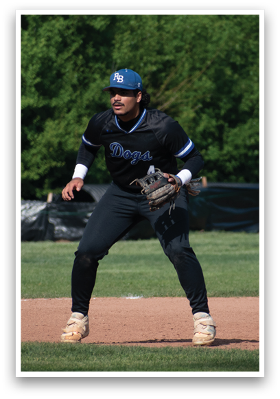 A baseball player in a black shirt and white shoes is standing on a baseball field. Description generated by AI