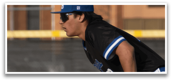 A baseball player wearing a blue hat and blue shoes. Description generated by AI