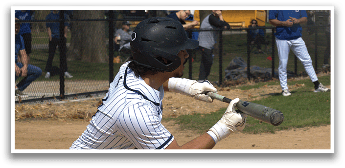 A baseball player in a blue and white uniform is swinging a bat. Description generated by AI