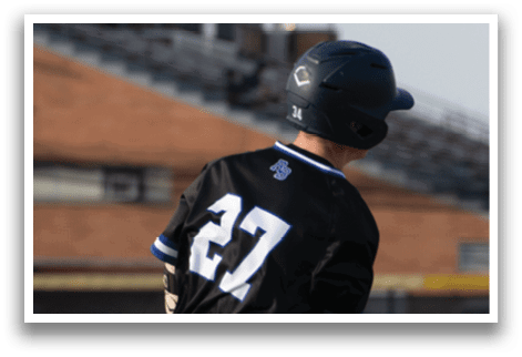 A baseball player in a black and white uniform is swinging a bat. Description generated by AI