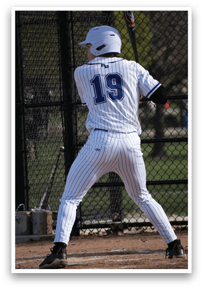 A baseball player in a white and blue uniform is swinging a bat. Description generated by AI
