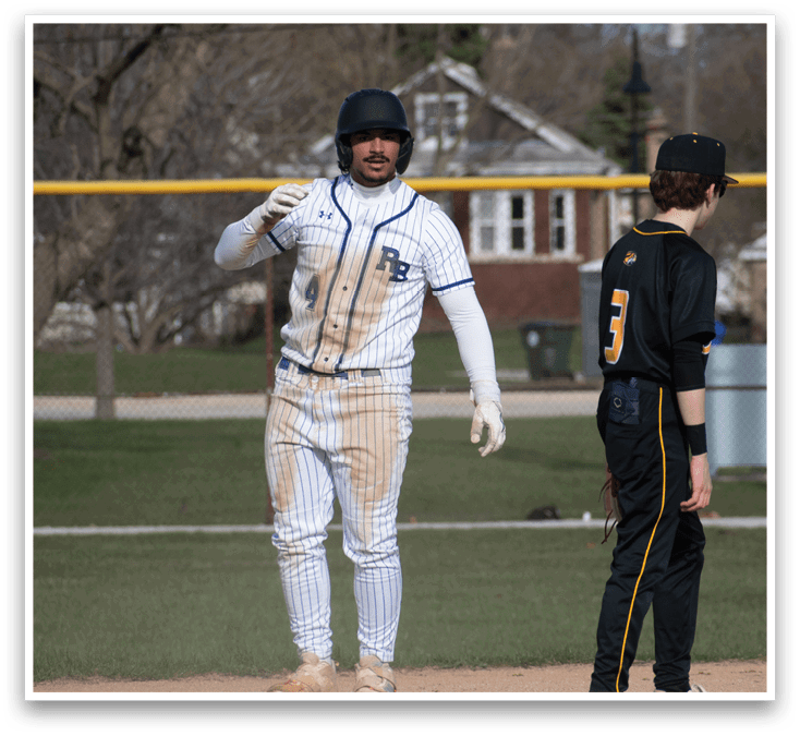 A baseball player wearing a white and blue uniform. Description generated by AI