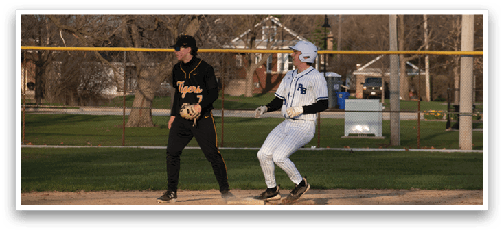 A baseball player in a white uniform is standing on the field. Description generated by AI