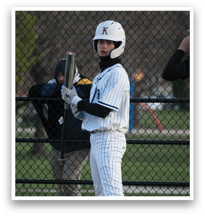 A baseball player in a white uniform holding a bat. Description generated by AI