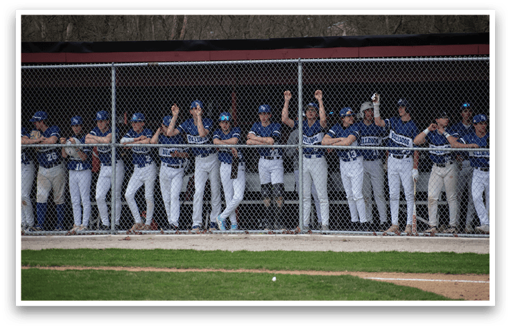 Baseball players in blue and white uniforms standing on a field. Description generated by AI