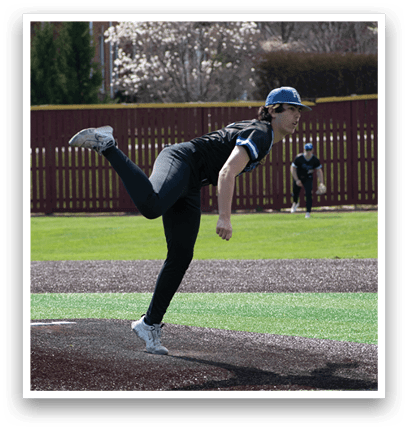 A baseball player in a black shirt and black pants is pitching a ball. Description generated by AI
