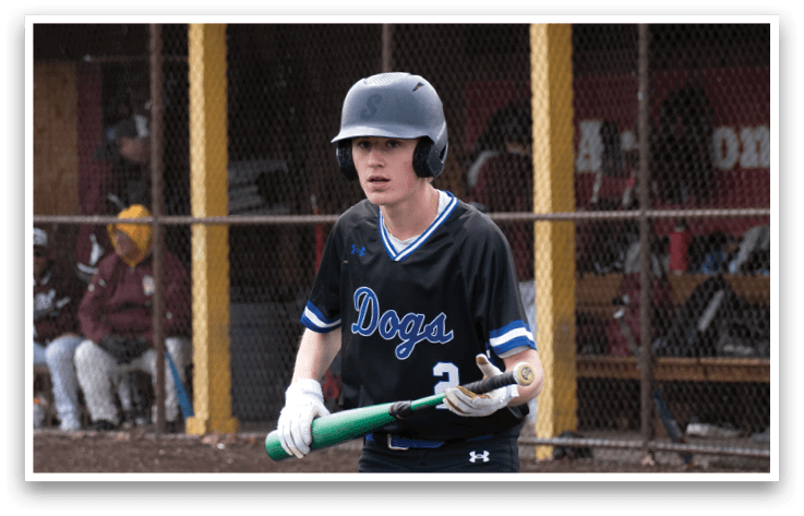 A boy in a blue and black baseball uniform holding a bat. Description generated by AI