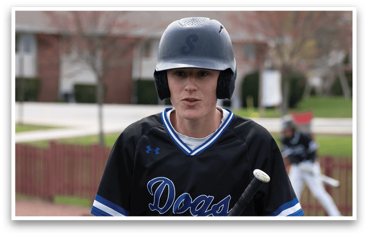 A baseball player wearing a black jersey with the word “Dogs" on it. Description generated by AI