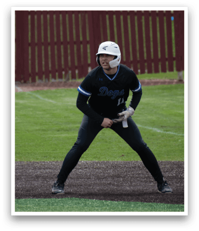 A baseball player in a black and blue uniform is ready to bat. Description generated by AI