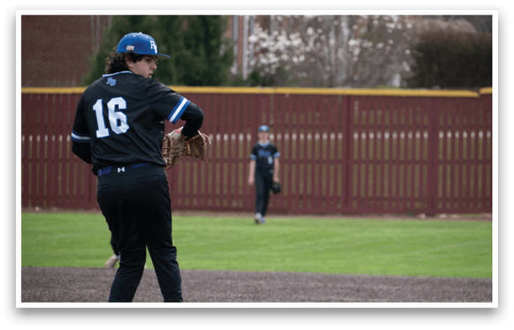A baseball player wearing a black shirt and blue hat is pitching a ball. Description generated by AI