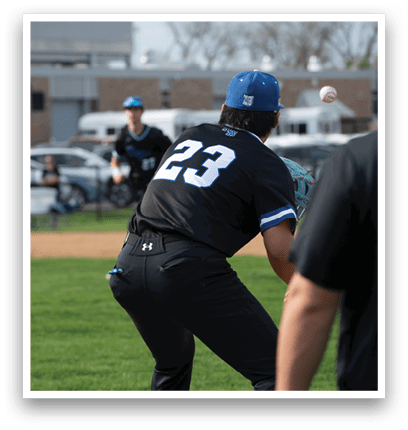 A baseball player wearing a black shirt and blue hat is trying to catch a ball. Description generated by AI