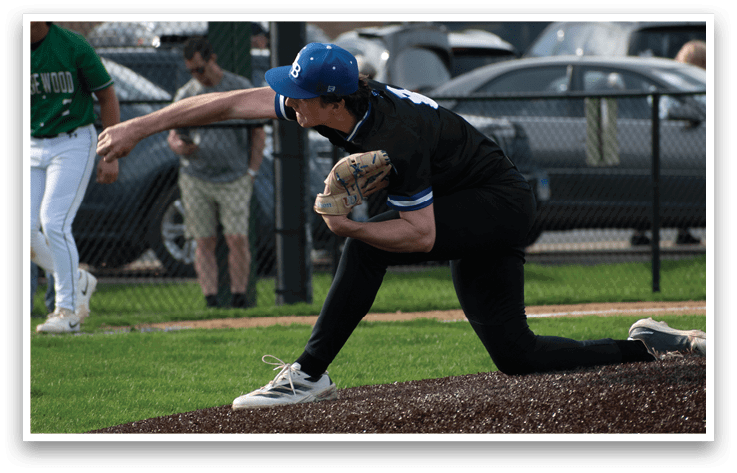A baseball player in a black shirt and blue hat is pitching a ball. Description generated by AI