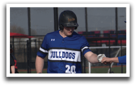 Two men wearing blue and white uniforms are standing on a baseball field. Description generated by AI