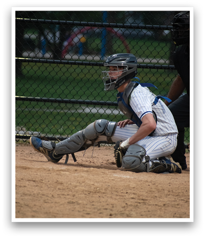A baseball player wearing a helmet and kneeling on the ground. Description generated by AI