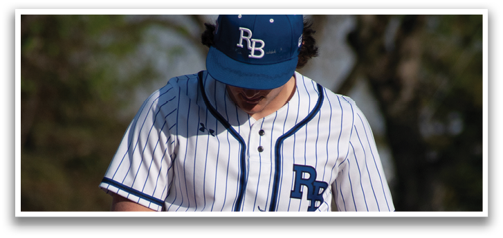 A baseball player wearing a blue and white uniform. Description generated by AI