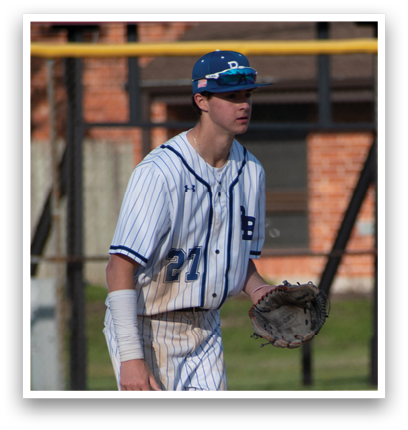 A baseball player wearing a blue and white uniform. Description generated by AI