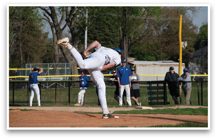 A baseball player in a white uniform is pitching a ball. Description generated by AI