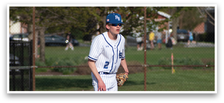 A baseball player wearing a blue cap and white uniform is walking on the field. Description generated by AI