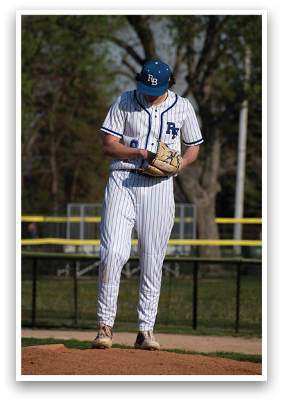 A baseball player wearing a blue and white uniform. Description generated by AI