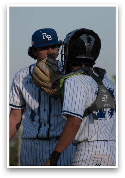 Two baseball players wearing blue and white uniforms. Description generated by AI