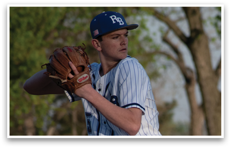 A baseball player in a blue and white uniform is pitching a ball. Description generated by AI