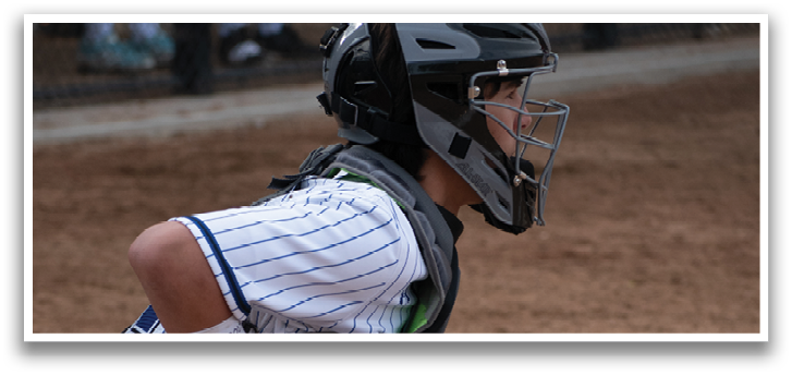 A baseball player wearing a helmet and kneeling down. Description generated by AI