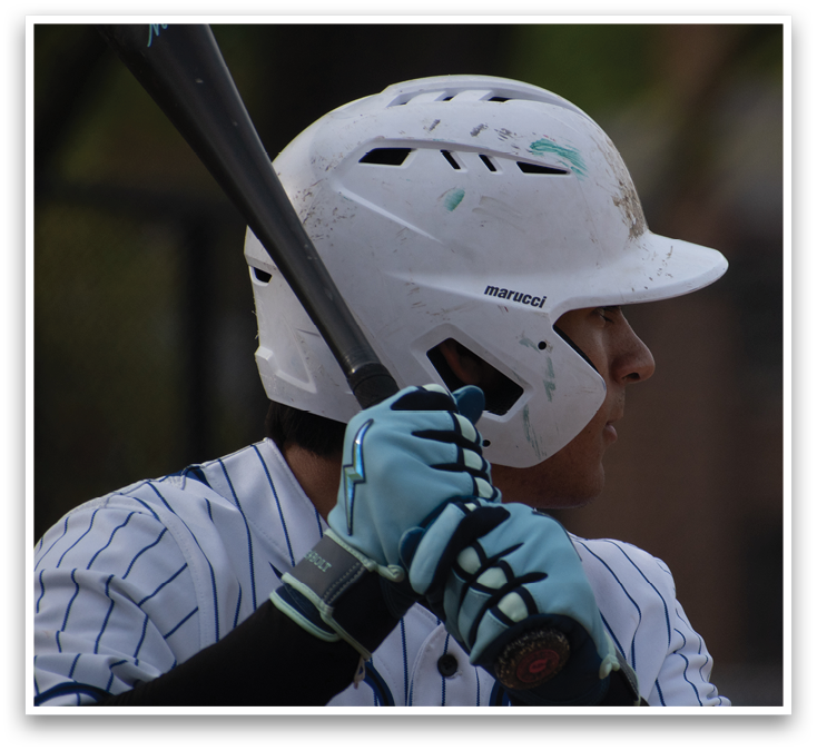 A baseball player wearing a blue and white uniform holding a bat. Description generated by AI