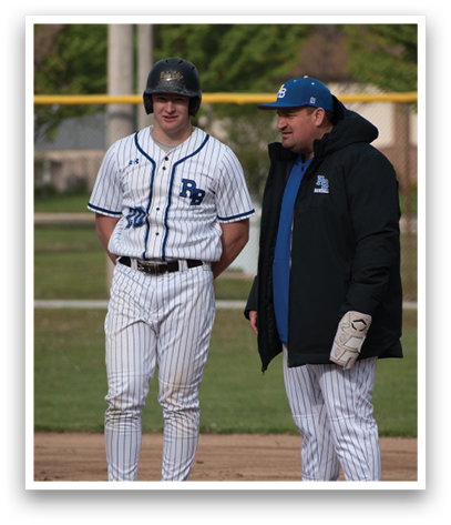 Two men standing on a baseball field. Description generated by AI