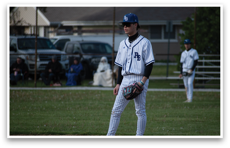 A baseball player wearing a blue and white uniform. Description generated by AI