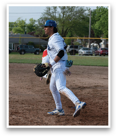 A baseball player wearing a blue hat and white uniform is running on the field. Description generated by AI