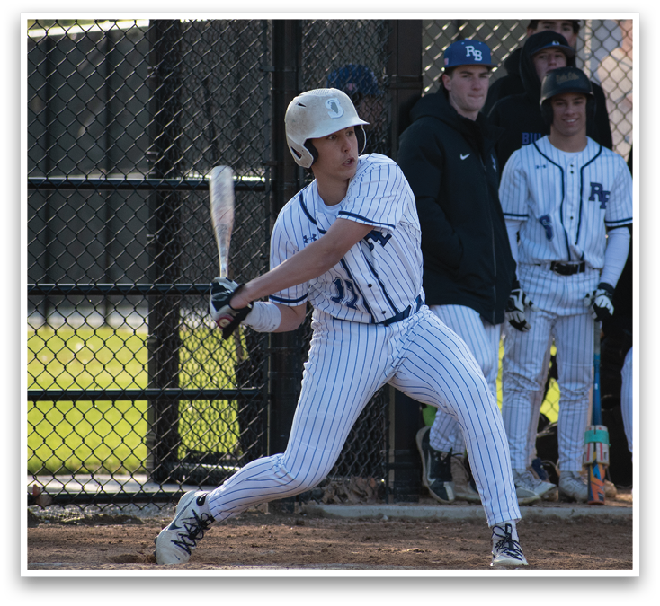 A baseball player in a blue and white uniform is swinging a bat. Description generated by AI