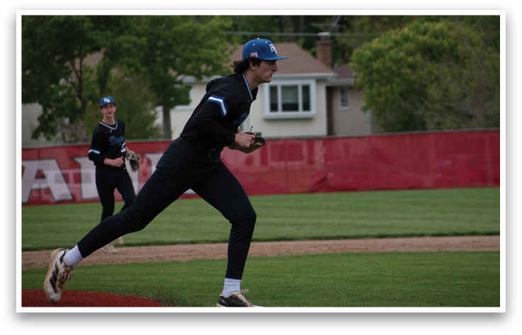 A baseball player in a black shirt and blue hat is running to the base. Description generated by AI