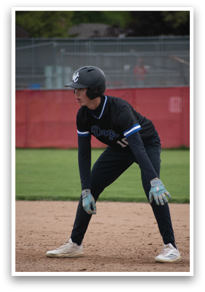 A baseball player wearing a black shirt and blue gloves. Description generated by AI