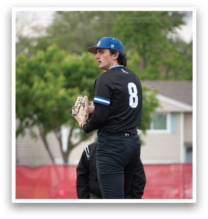 A baseball player wearing a black shirt and hat with the number 8 on it. Description generated by AI
