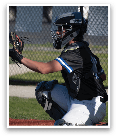 A baseball player wearing a black and blue shirt and white pants is kneeling on the ground. Description generated by AI