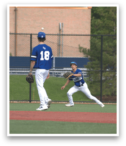 A baseball player wearing a blue shirt and white pants is about to catch a ball. Description generated by AI