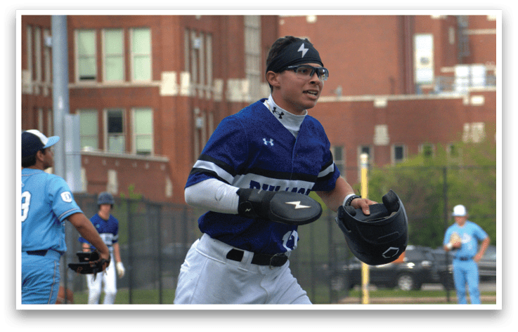 A baseball player wearing a blue shirt and white pants with a black glove. Description generated by AI