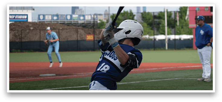 A baseball player in a blue and white uniform is swinging a bat. Description generated by AI