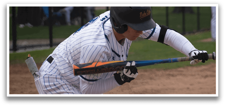 A baseball player in a blue and white uniform is swinging a bat. Description generated by AI