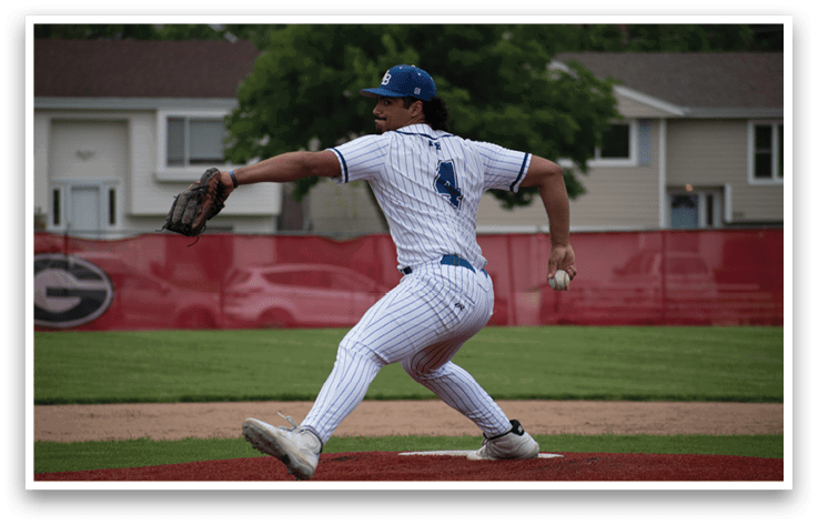 A baseball player in a white and blue uniform is pitching a ball. Description generated by AI