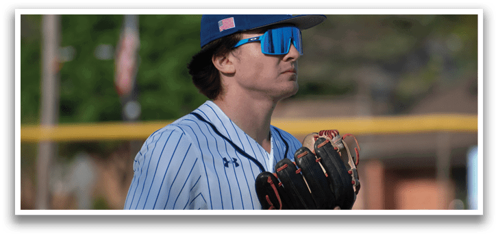 A baseball player wearing a blue and white shirt and a blue hat. Description generated by AI